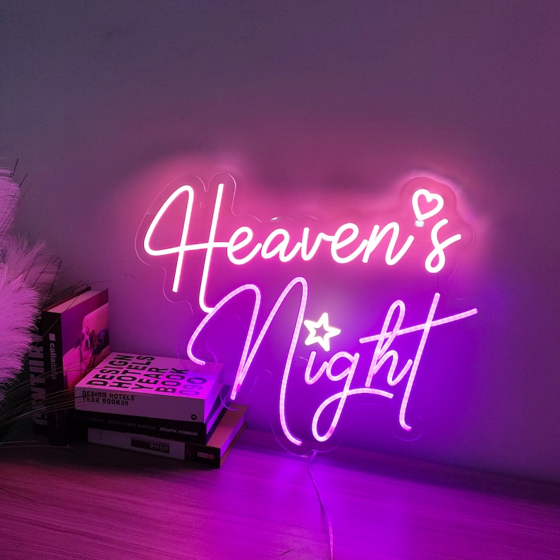 Puede incluir: Letrero de ne&oacute;n rosa con el texto "Heaven's Night" con un peque&ntilde;o coraz&oacute;n y una estrella sobre las palabras.