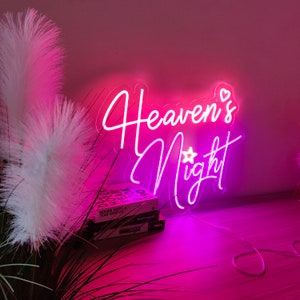 Puede incluir: Letrero de ne&oacute;n rosa con el texto "Heaven's Night" con un peque&ntilde;o gr&aacute;fico de estrella y coraz&oacute;n.