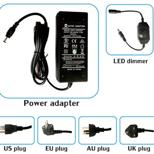Puede incluir: Un adaptador de corriente negro con opciones de enchufe US, EU, AU y UK. El adaptador tiene una etiqueta que dice "AC/DC ADAPTER MODEL WOY-12005000 INPUT:100-240Vac 2.0A 50/60Hz OUTPUT: 12V=3A CE FC SAA CAUTION WARNING MADE IN CHINA". Tambi&eacute;n se muestra un atenuador LED negro con una perilla giratoria.