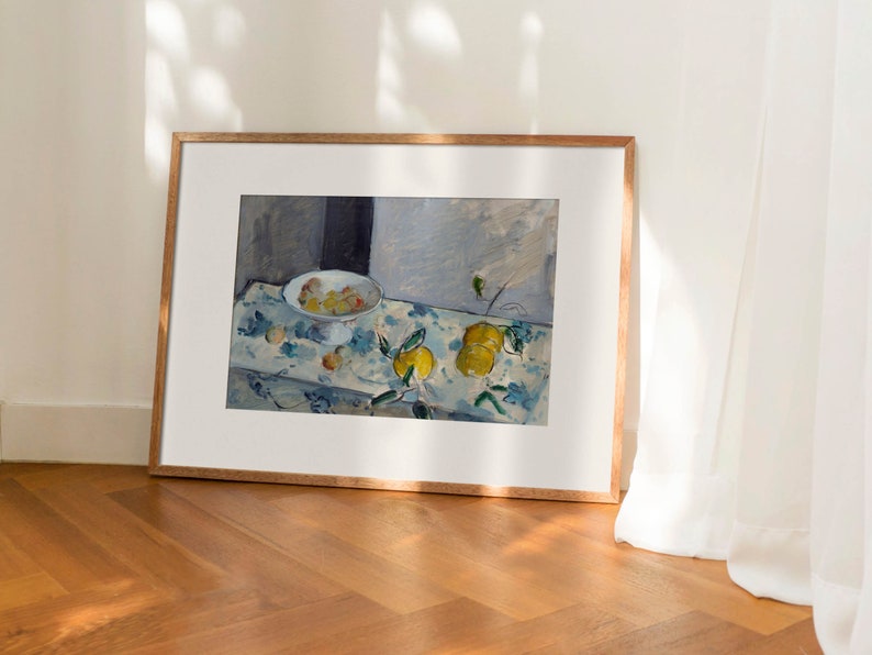 May include: A framed painting of a still life with a bowl of fruit and lemons on a table with a blue and white patterned tablecloth.