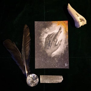 Könnte beinhalten: Eine Schwarzweißillustration einer Hand mit einem darauf gezeichneten Symbol. Die Hand zeigt nach oben und ist von einem dunklen Hintergrund mit weißen Punkten umgeben. Das Bild ist auf einer weißen Karte.