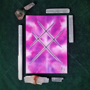 May include: A pink and purple watercolor painting with a black geometric design in the center. The painting is surrounded by selenite crystals.