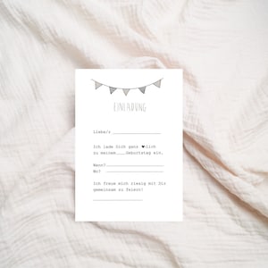 May include: A white card with black text and a simple illustration of a string of flags. The text reads "EINLADUNG" and includes the phrase "Ich lade Dich ganz herzlich zu meinem Geburtstag ein."  The card also has blank lines for the date, time, and location of the event.