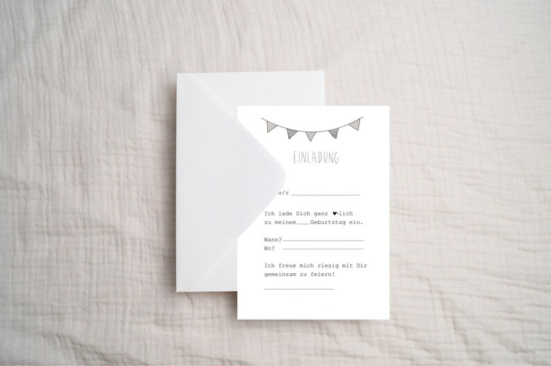 May include: A white card with a black and gray bunting at the top. The text "EINLADUNG" is written in black below the bunting. The text "Ich lade Dich ganz herzlich zu meinem Geburtstag ein." is written in black below the text "EINLADUNG". The text "Wann?" and "Wo?" are written in black below the text "Geburtstag ein.". The text "Ich freue mich riesig mit Dir gemeinsam zu feiern!" is written in black below the text "Wo?"