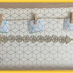 May include: A gold beaded bracelet with a floral design. The bracelet is displayed on a white background with a geometric pattern. The number 2079 is visible in the bottom left corner of the image.