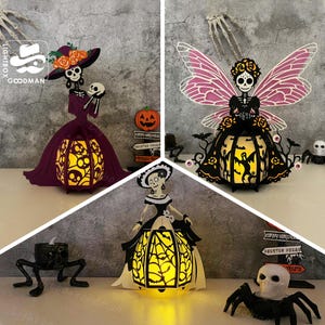 May include: Three Halloween paper lanterns shaped as skeleton figures. One is a woman in a purple dress and hat, another a fairy with pink wings, and the third a woman in a black dress. Each lantern has a cutout design that glows with an internal light.