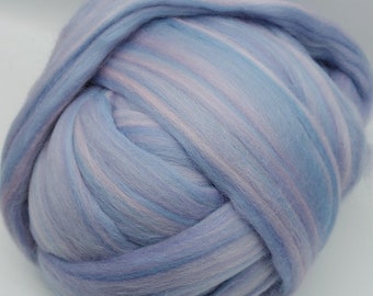 Könnte beinhalten: Eine Kugel aus hellblauer und rosa Wollroving. Die Wolle ist in einem wirbelnden Muster angeordnet.
