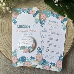 Peut inclure: Un ensemble de faire-part de mariage avec un motif floral aux fleurs roses, bleues et blanches et des feuilles vertes. L'ensemble comprend une carte, un programme et un bouton avec le texte "MARIAGE DE Karine et Olivier - 22 JUIN 2024-".