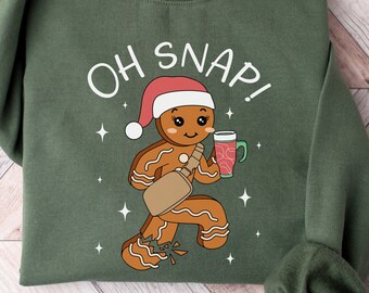 Könnte beinhalten: Grünes Sweatshirt mit einem Lebkuchenmann-Motiv und dem Aufdruck "OH SNAP!" auf der Vorderseite.