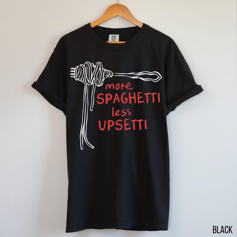 May include: Black t-shirt with a white illustration of a fork with spaghetti on it. The text "more spaghetti less upsetti" is written in red.