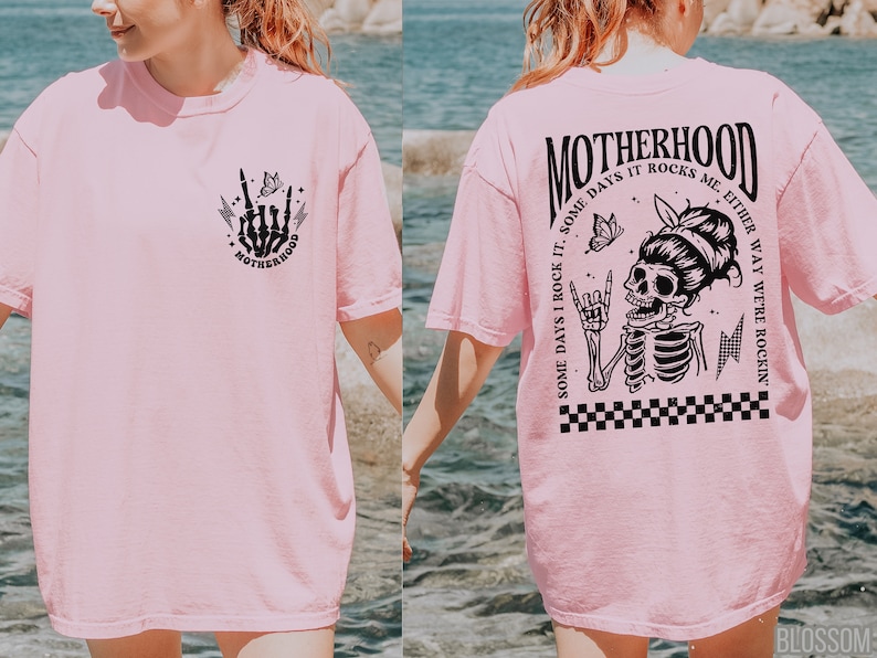 May include: Pink t-shirt with a black skeleton graphic and the text "MOTHERHOOD SOME DAYS I ROCK IT. SOME DAYS IT ROCKS ME, EITHER WAY WE'RE ROCKIN'" on the back. The front of the shirt has a smaller black skeleton hand graphic with the word "MOTHERHOOD" underneath.