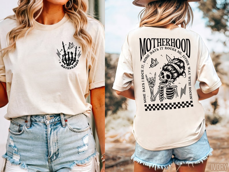 May include: A cream colored t-shirt with a black and white graphic of a skeleton with a butterfly and the text "MOTHERHOOD SOME DAYS I ROCK IT. SOME DAYS IT ROCKS ME. EITHER WAY WE'RE ROCKIN'" on the back. The front of the shirt has a smaller graphic of a skeleton hand with a butterfly and the text "MOTHERHOOD".