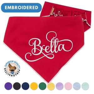 May include: Red dog bandana with white embroidered text "Bella" and a white border. The bandana is folded in half and has a white satin trim. The bandana is shown against a white background with a variety of color options below.