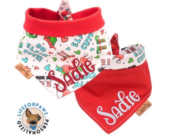 Könnte beinhalten: Zwei personalisierte Hunde-Bandanas. Eines ist rot mit dem Namen "Sadie" in Weiß gestickt. Das andere ist weiß mit rotem Rand und zeigt Elf-Grafiken, Herzen und den Text "So Elf Cute!" und "Sadie".