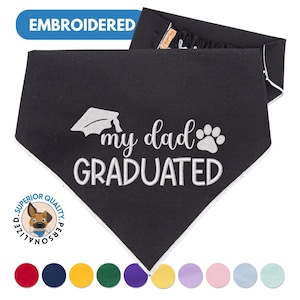 May include: Black dog bandana with white embroidery that says "My Dad Graduated" with a graduation cap and paw print. The bandana has a white border and is available in a variety of colors.