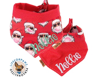 Könnte beinhalten: Zwei rote Hunde-Bandanas mit weißen Punkten und einem sich wiederholenden Muster von Weihnachtsmännern mit Sonnenbrille und Kaugummi. Ein Bandana hat den Namen "Nellie" grün gestickt. Die Bandanas sind oben gebunden.