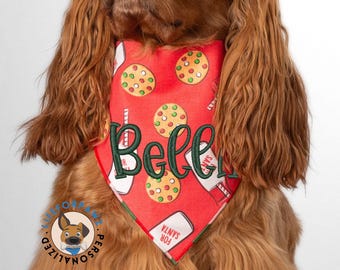 Könnte beinhalten: Rotes Hunde-Bandana mit einem Weihnachtskeksmuster und dem Namen "Belle" in Grün gestickt. Das Bandana zeigt auch Bilder von Milchkartons und den Text "FOR SANTA".