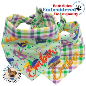 May include: Reversible dog bandana with a green and white plaid pattern on one side and a green background with Mardi Gras themed illustrations and the name "Ember" embroidered in orange on the other side.