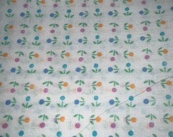 May include: White fabric with a repeating pattern of small green leaves, blue, orange, and pink dots.