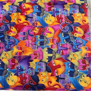 May include: A vibrant fabric featuring a repeating pattern of stylised cat faces. The design incorporates a range of colours including blue, orange, red, purple, and green, with gold detailing. The edge of the fabric has the text "Fabulous Felines".