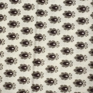 May include: A white fabric with a repeating pattern of brown paisley shapes. The fabric has a subtle texture.