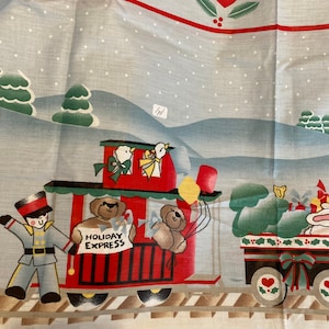 May include: A vintage fabric featuring a red, white and blue train with a teddy bear conductor and the words "Holiday Express". The train is surrounded by green trees and red hearts. The fabric has a white background with a light blue snow pattern.