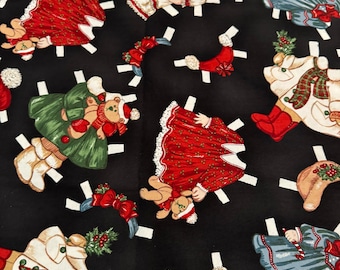 May include: Black fabric with a repeating pattern of paper dolls dressed in Christmas-themed outfits. The dolls are wearing red, green, blue, and white dresses with various accessories. The fabric is perfect for crafting projects like quilts, pillows, and bags.