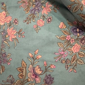 Peut inclure: Un tissu turquoise avec un motif floral. Les fleurs sont roses, violettes et jaunes. Le tissu a une texture subtile.