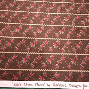 Op de afbeelding: Bruine stof met een herhalend patroon van roze rozen en groene bladeren. Witte, golvende strepen scheiden de rijen bloemmotieven. De tekst "Ella's Linen Closet" by Blackbird Designs is gedrukt op een witte strook.