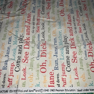 May include: Fabric with repeating text from the "Dick and Jane" series in red, orange, and blue. The words "See Dick and Jane" are prominent. The fabric has a cream-colored background.