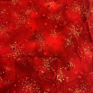 Może przedstawiać: Czerwony materiał z wzorem złotych konfetti. Wzór zawiera gwiazdki, spirale i kwadraty.