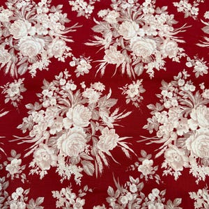 Może przedstawiać: Czerwona tkanina z białym kwiatowym wzorem, w tym róże i inne kwiaty. Tkanina zawiera tekst "Vintage Rouge", "design 4383" i "Faye Burgos". Tkanina pochodzi z MARCUS Fabrics.