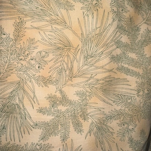Pode incluir: Um tecido bege com um padrão repetido de ramos de pinheiro verdes e bagas.