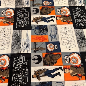 Könnte beinhalten: Ein schwarz-weißes Stoffmuster mit sich wiederholenden Star Wars-Charakteren und dem Text "Star Wars: Das Erwachen der Macht". Die Charaktere sind Rey, Finn, Kylo Ren, Chewbacca und BB-8.