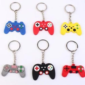 May include: Six colorful video game controller keychains. The keychains are in blue, red, yellow, gray, black, and red. Each controller has a silver keyring attached. The controllers have buttons in various colors.