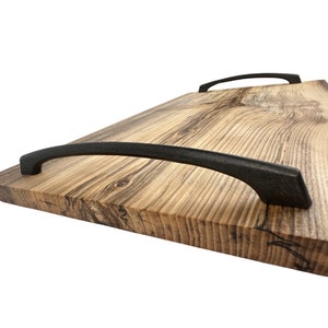 May include: A wooden serving tray with two black metal handles. The tray is made of natural wood with a rustic finish.