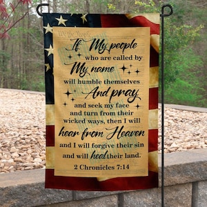 May include: A garden flag featuring the American flag design with the text "If My people..." from 2 Chronicles 7:14. The flag has a parchment-like center with black script and star accents, set against a backdrop of red, white, and blue.