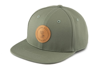 May include: A green and brown baseball cap with a leather patch featuring a palm tree and the text "CUBS & CO."