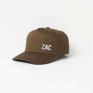 May include: A brown baseball cap with a white embroidered logo that says "ZAC".