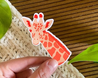 May include: A sticker of a pink and orange giraffe with a white background. The giraffe is looking to the left and has a long neck and spots.