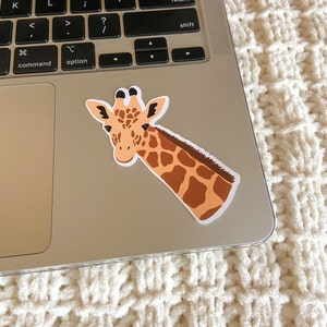 May include: A brown and tan giraffe sticker with black eyes and a white background. The giraffe is looking to the left and has its head tilted.