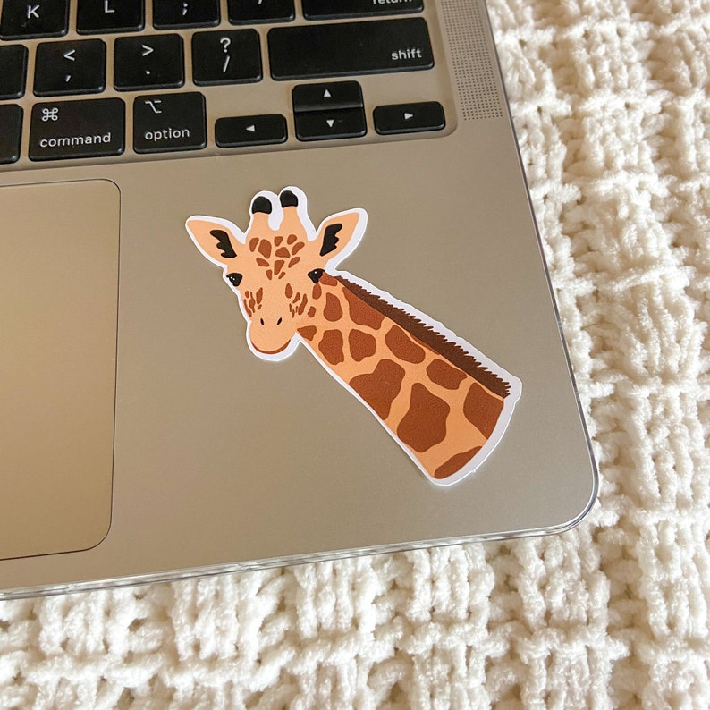 May include: A brown and tan giraffe sticker with black eyes and a white background. The giraffe is looking to the left and has its head tilted.
