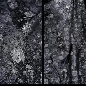 May include: Close-up of a dark fabric with a textured surface and a pattern of silver-colored, irregular shapes. The fabric appears to be draped, with folds and shadows adding depth to the design. The overall effect is one of luxury and sophistication.