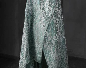 May include: A teal and white patterned fabric draped over a stand. The fabric has a marbled or swirled design.