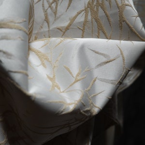 May include: White fabric with a subtle embossed pattern of beige bamboo branches.