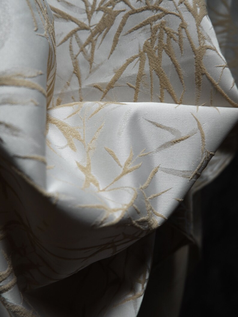 May include: White fabric with a subtle embossed pattern of beige bamboo branches.
