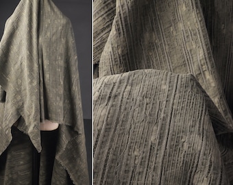 May include: A close-up of a textured, gray fabric with vertical lines. The fabric has a slightly crinkled appearance.