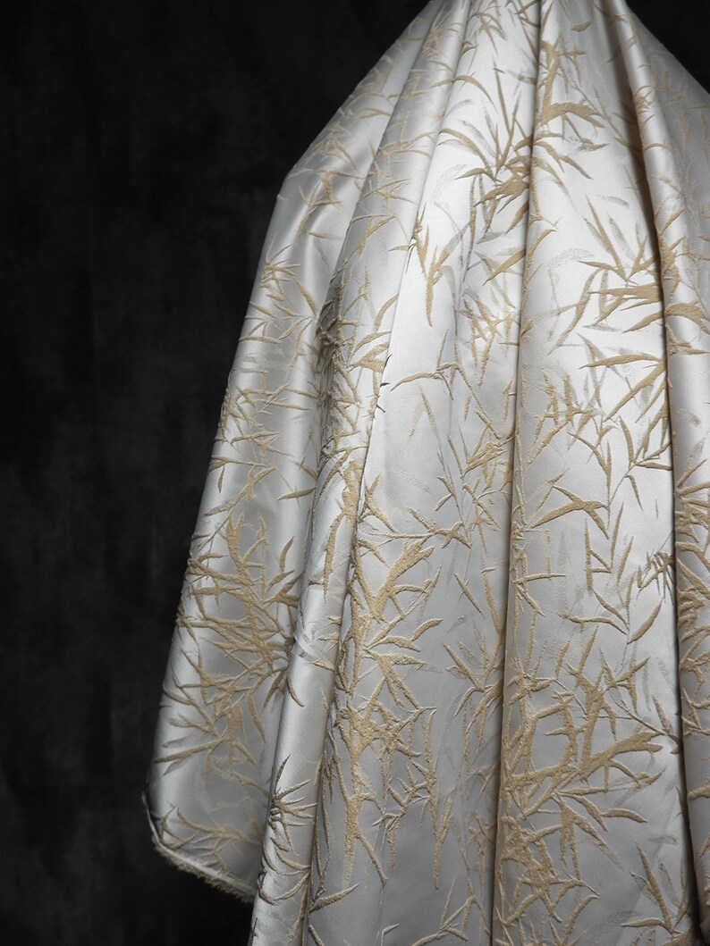May include: White fabric with a raised embossed pattern of beige bamboo leaves.