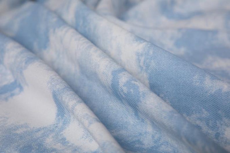 Op de afbeelding: Close-up van een zachte, blauw-witte tie-dye stof met een gekreukelde textuur.