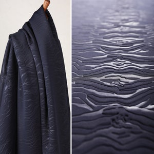 May include: A dark blue fabric with a textured, wavy pattern. The fabric has a soft, plush feel.
